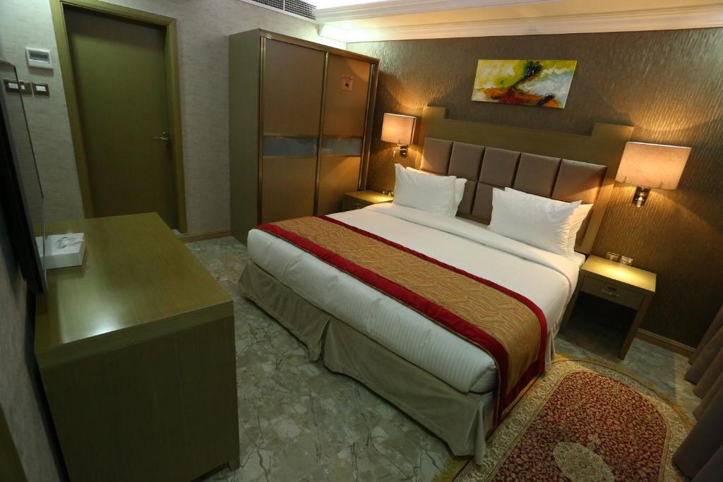 a hotel room with a large bed and a desk at Sun and Sands Plaza Hotel in Dubai