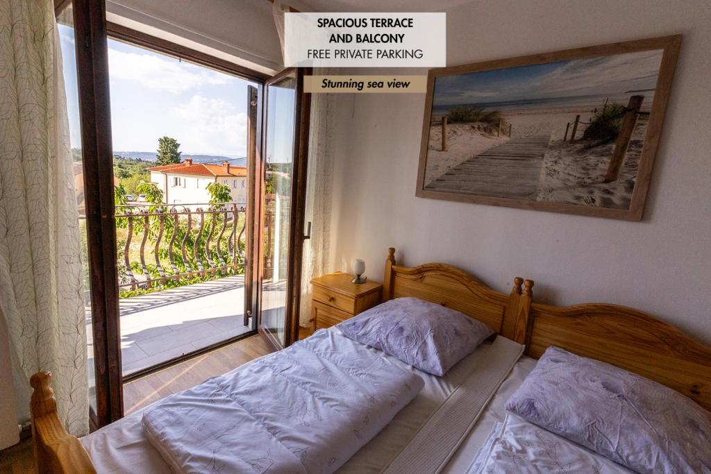 a bedroom with a bed and a balcony with a sign at Apartment Stefanija in Ankaran