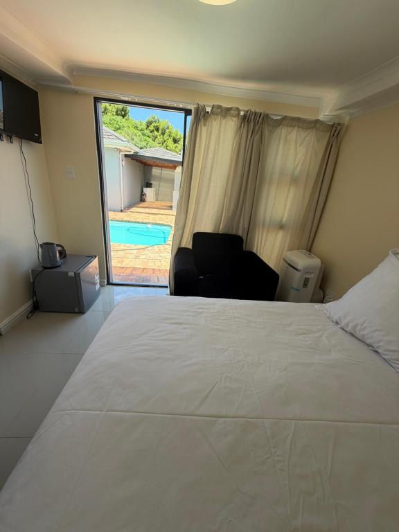 a bedroom with a bed and a chair and a pool at Joys House in Cape Town