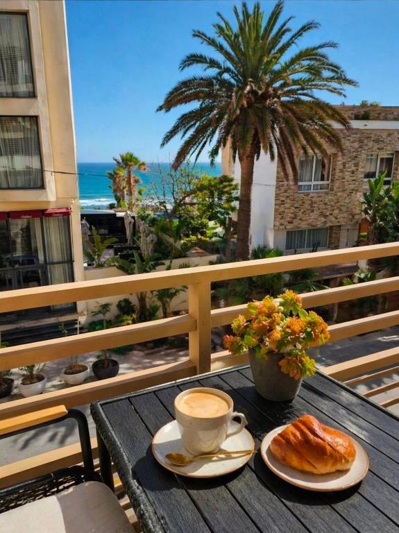 a table with a cup of coffee and croissants on a balcony at Auralys Seaside Studio avec balcon in Casablanca