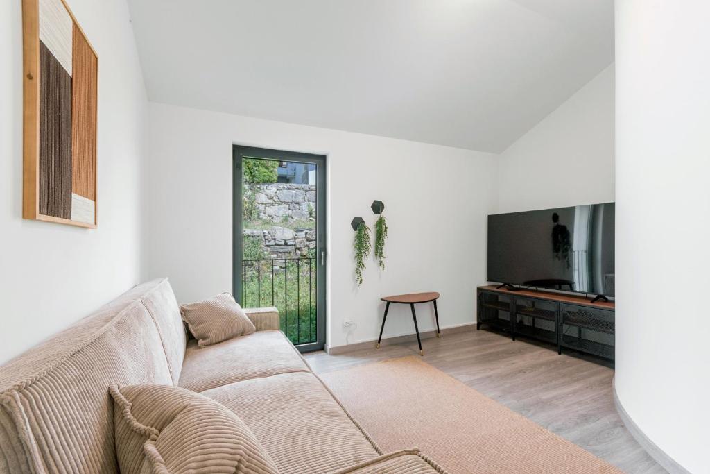 a living room with a couch and a tv at Casa do Recanto - Loriga - Serra da Estrela in Loriga