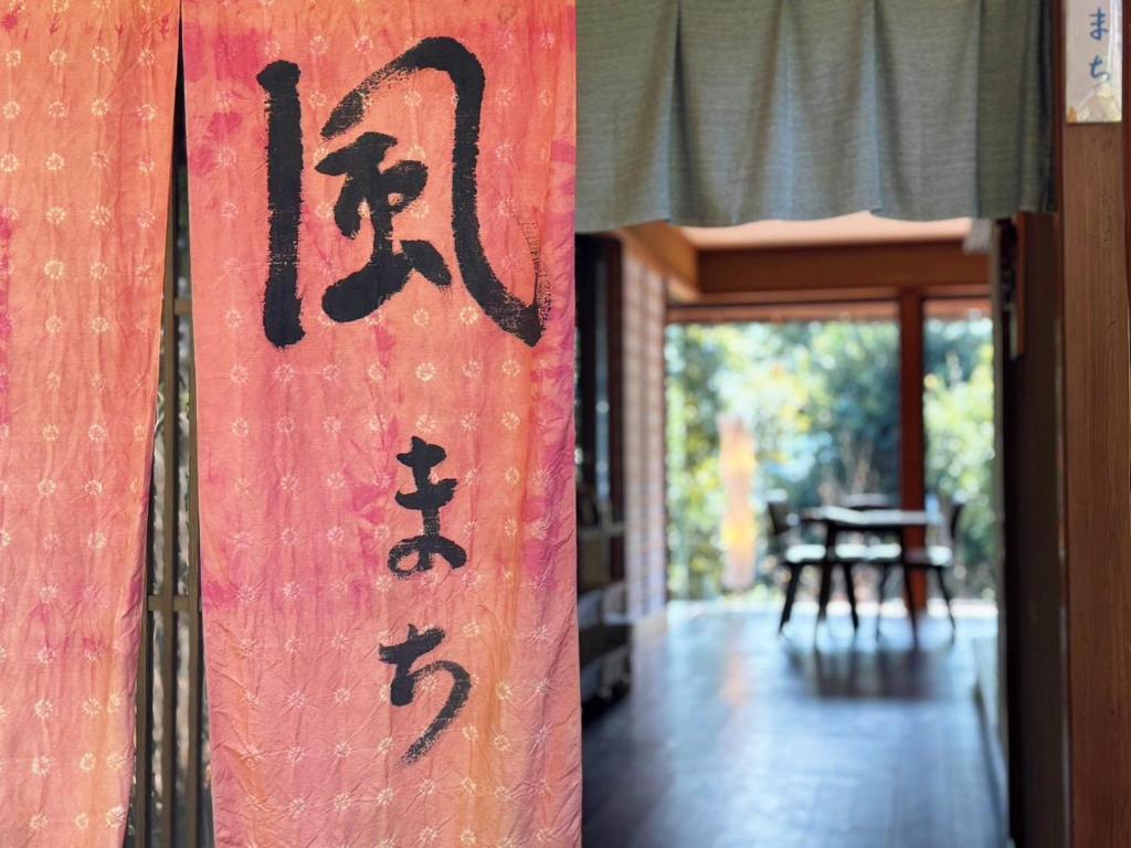 an asian sign on the side of a building at 風まち in Yawatano