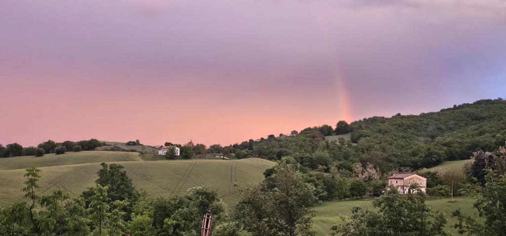 a rainbow in the sky over a green field at Orchard House North in Pergola