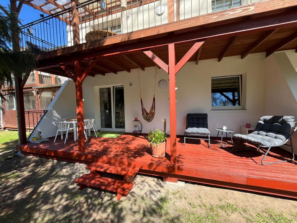 a large wooden deck with two chairs and a table at Łagów apartament z plażą i pomostem in Łagów