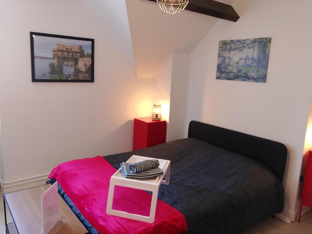 a bedroom with a bed with a small table on it at L'escale Vernonnaise in Vernon