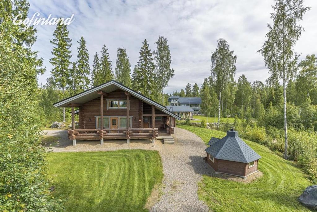 a log cabin in the middle of a yard at Holiday Home Tattimetsä in Sysmä