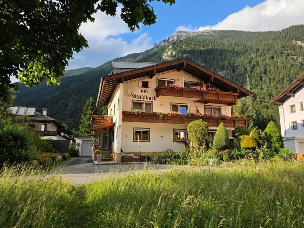 a house with a mountain in the background at am Mühlbach - Ferienwohnungen Luttinger in Bichlbach