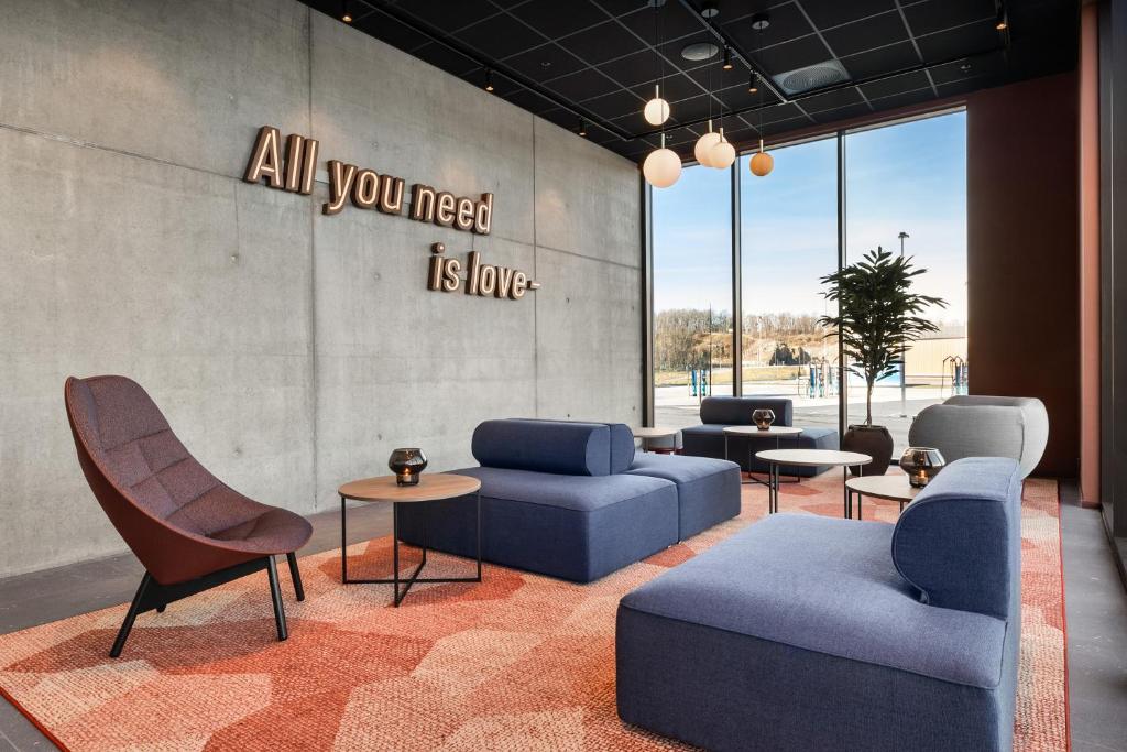 a lobby with couches and tables and a sign on the wall at Comfort Hotel Grenlandsporten in Langangen