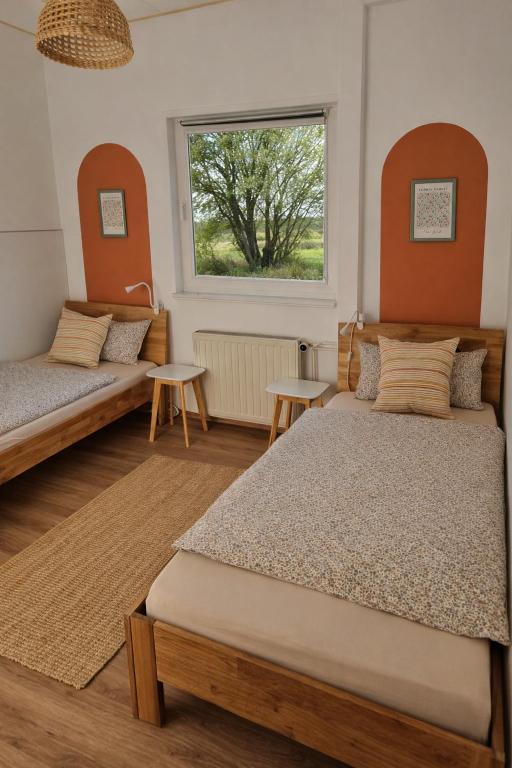a bedroom with two beds and a window at House of Flow in Pritzwalk