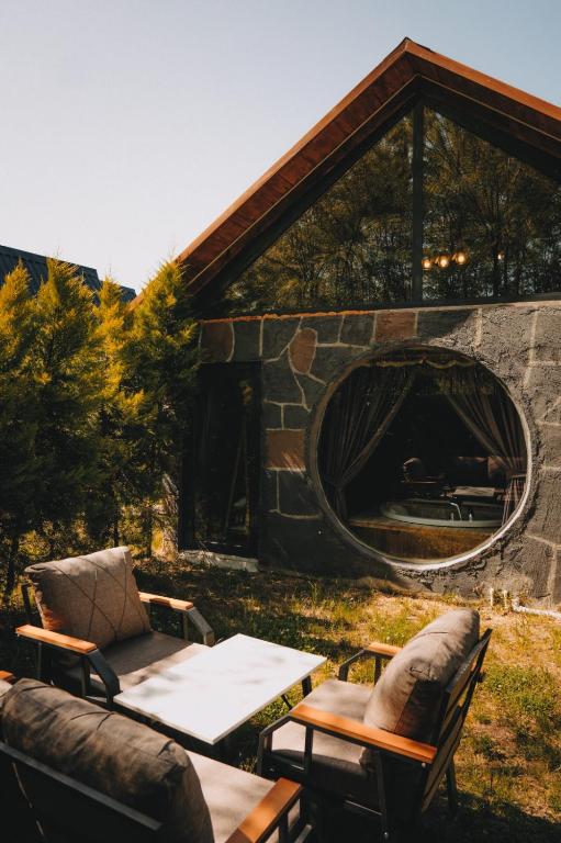 a patio with a table and chairs and a fireplace at Yeşil Cennet Tatil Köyü in Pazar
