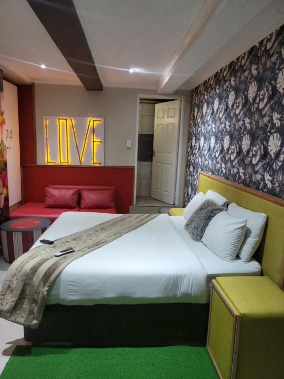 a bedroom with a large bed and a living room at Tshilidzi Guest House in Pretoria