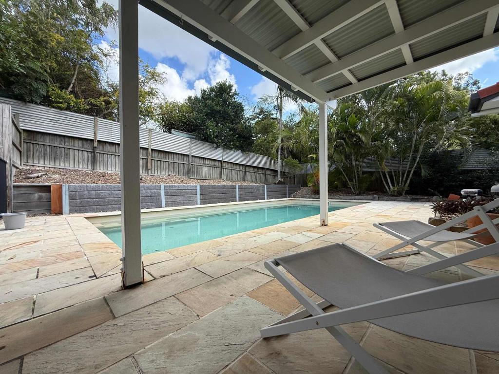 a patio with a chair and a swimming pool at Midtown Oasis - Sleeps 9 in Scarness