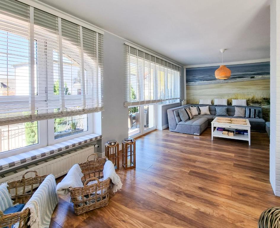 a living room with a couch and chairs and windows at visit baltic - Villa Blue Marine in Świnoujście