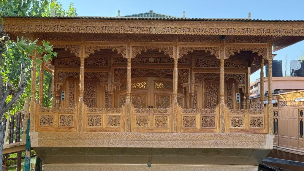 a wooden building with a wooden fence at Suroor Houseboat in Srinagar