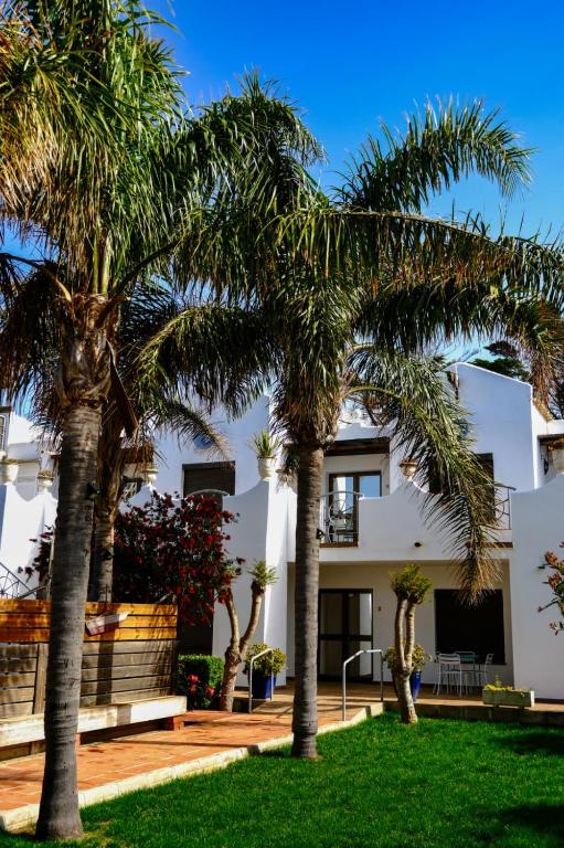 a house with palm trees in front of it at Apartamentos Hacienda Sajorami in Zahora