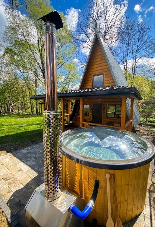 a hot tub in front of a house at Bieszczadzki Reset A-Frame in Bukowiec