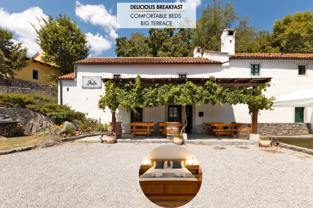 a large white building with a sign in front of it at Kraška hiša Škrla in Divača