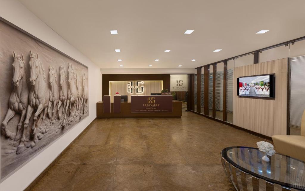 a lobby with a large painting on the wall at Hotel Hemaadri Grand in Hyderabad