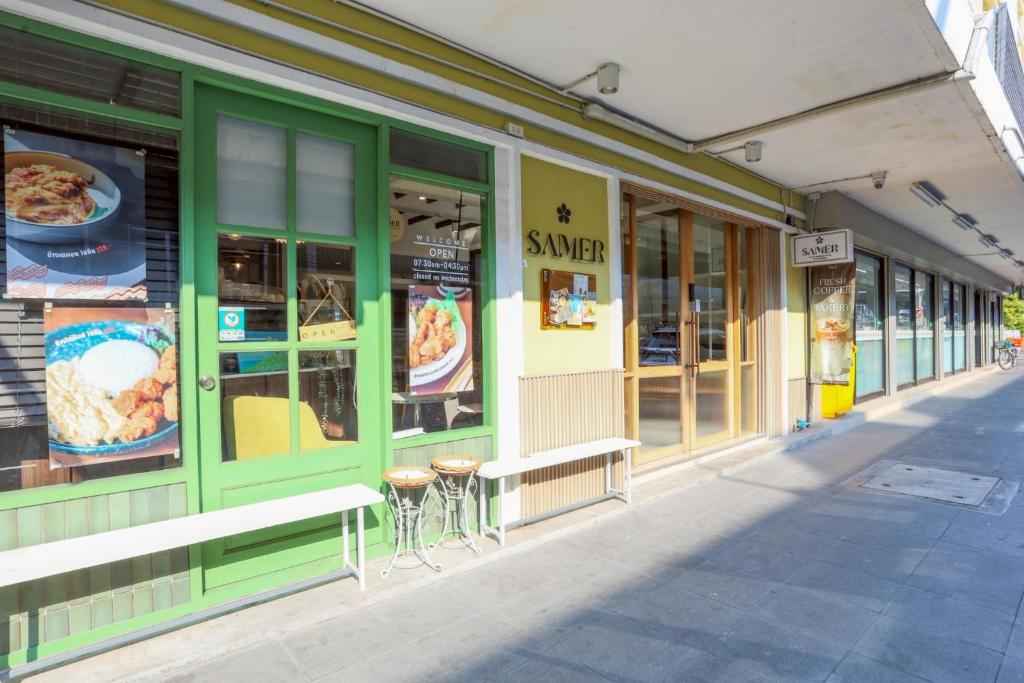 a store front with green trim on a street at Samer Boutique Stay in Bangkok