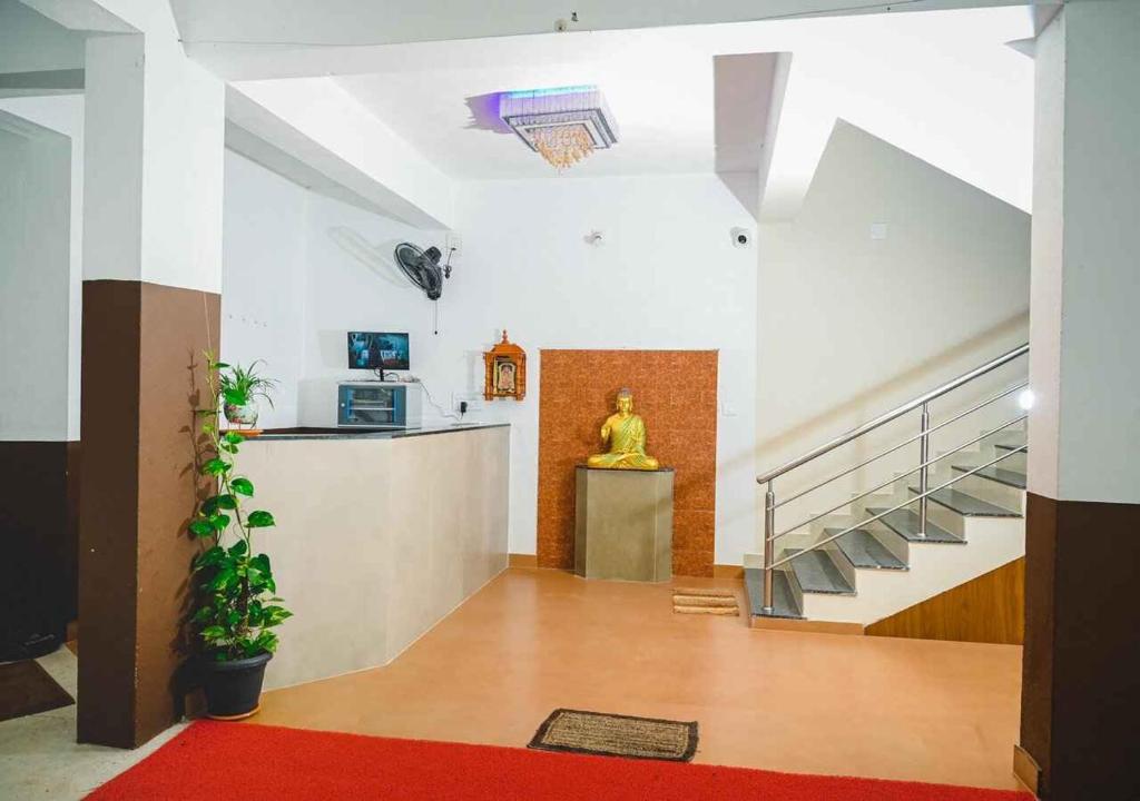 a lobby with stairs and a statue in the middle at Ocean Breeze Service Apartment in Malpe