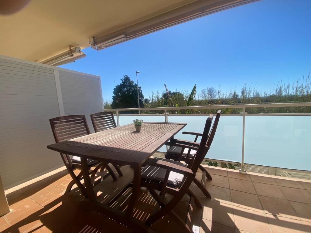 a wooden table and chairs on a balcony with a view at Apartament Sara in L'Eucaliptus