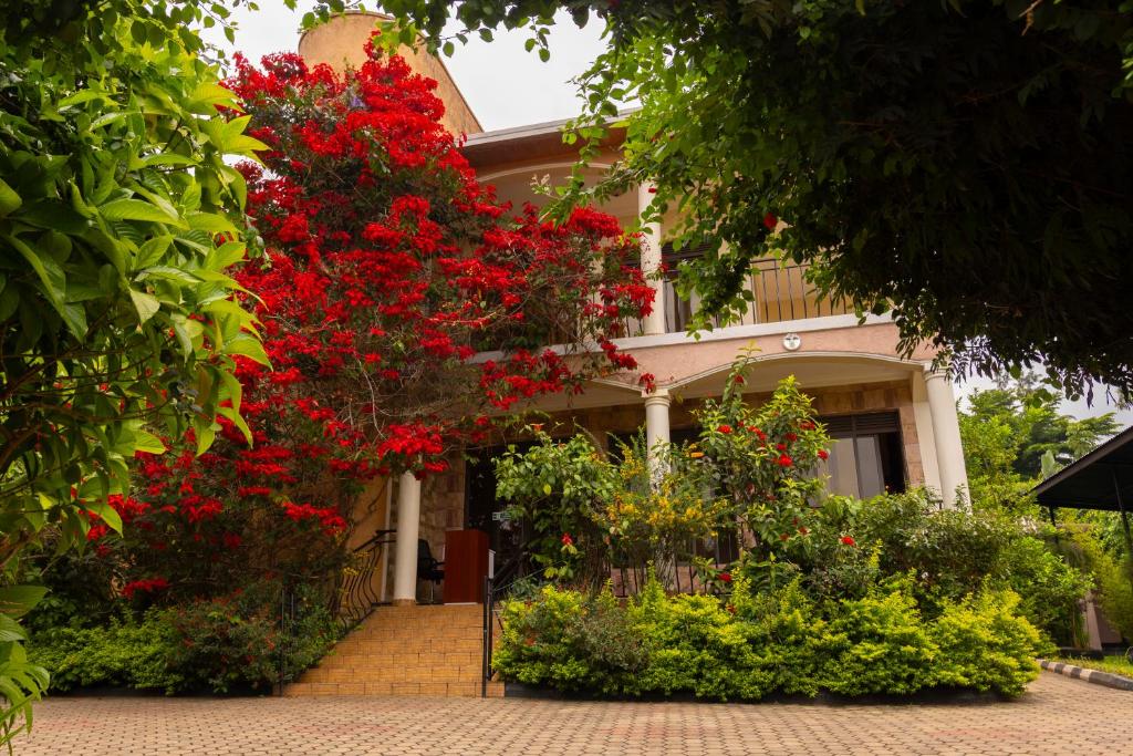 a house with red flowers in front of it at UmuTea Villa - Authentic East African local experience in Kigali