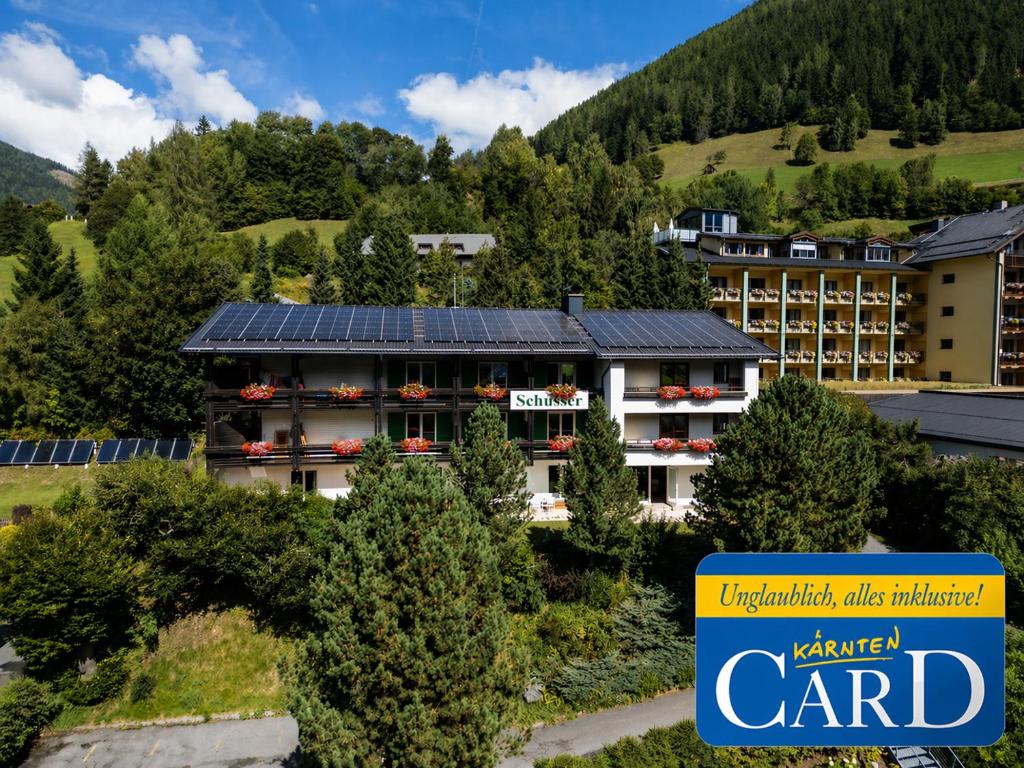 a hotel with solar panels on the roof at Gästehaus Schusser an der Therme, Frühstück, Doppelzimmer und Ferienwohnung in Bad Kleinkirchheim