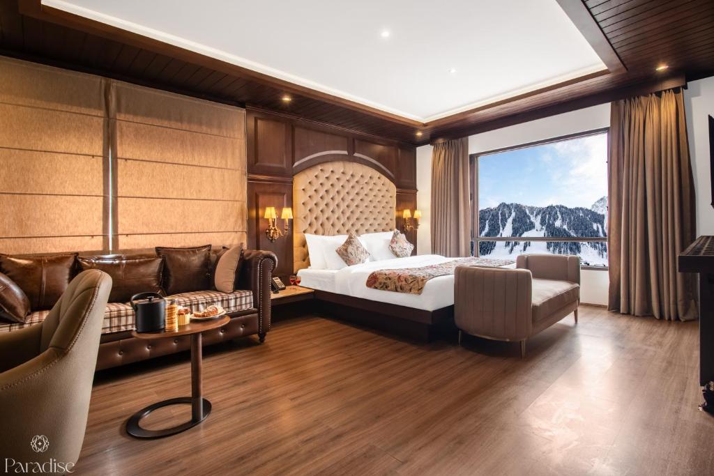 a hotel room with a bed and a large window at Paradise Hotels in Pahalgām