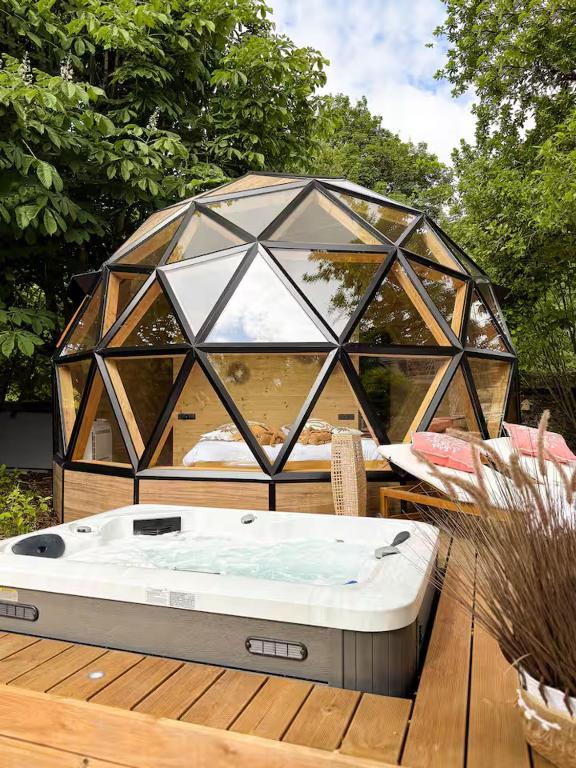 a hot tub sitting on top of a wooden deck at L'Échappée Bulle - Dôme & jacuzzi - Bastogne Centre in Bastogne