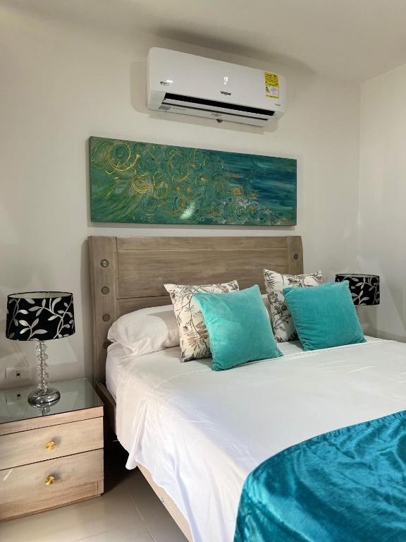 a bedroom with two beds with blue pillows at Apartamento COMPLETO Nuevo Norte de Valledupar-1 Habitación, Balcón y Parqueadero in Valledupar