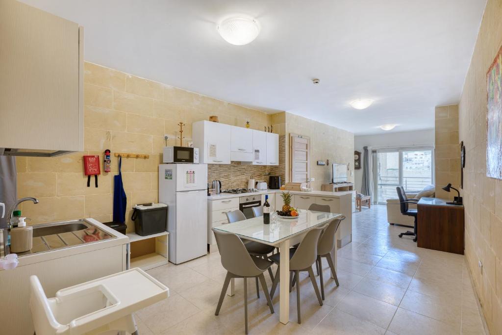a kitchen and dining room with a table and chairs at Staytopus Offshore Marsalforn Budget Room for Divers & Travelers in Marsalforn