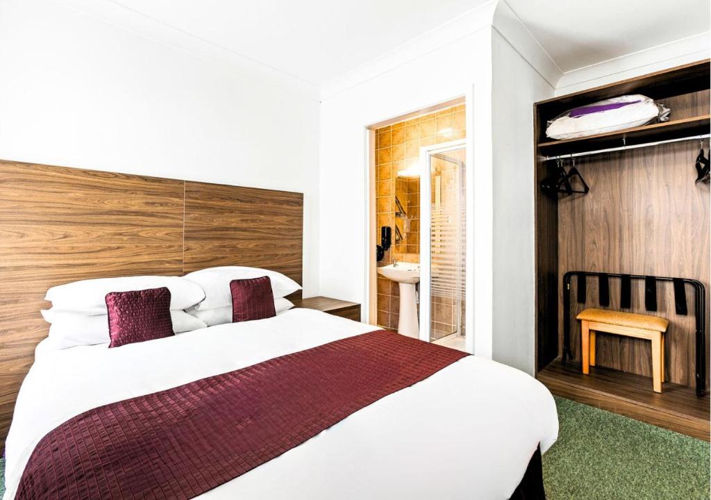 a bedroom with a large bed and a bathroom at Sandy Lodge Hotel Newquay in Newquay