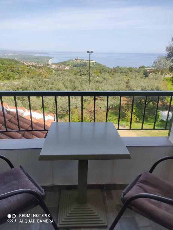 a table on a balcony with a view of the ocean at Thea apartments 2 in Platamonas