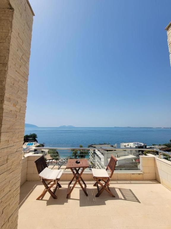 a patio with two chairs and a table on a balcony at Hotel Lusini in Vlorë
