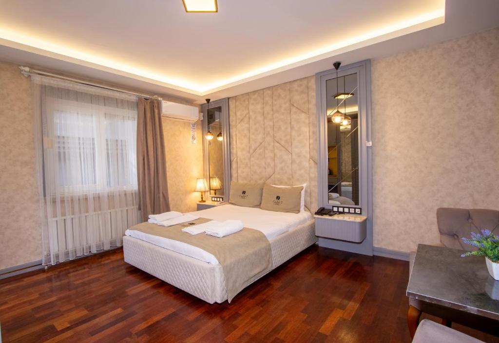 a bedroom with a large white bed in a room at Cadde 7 Otel in Bahçelievler
