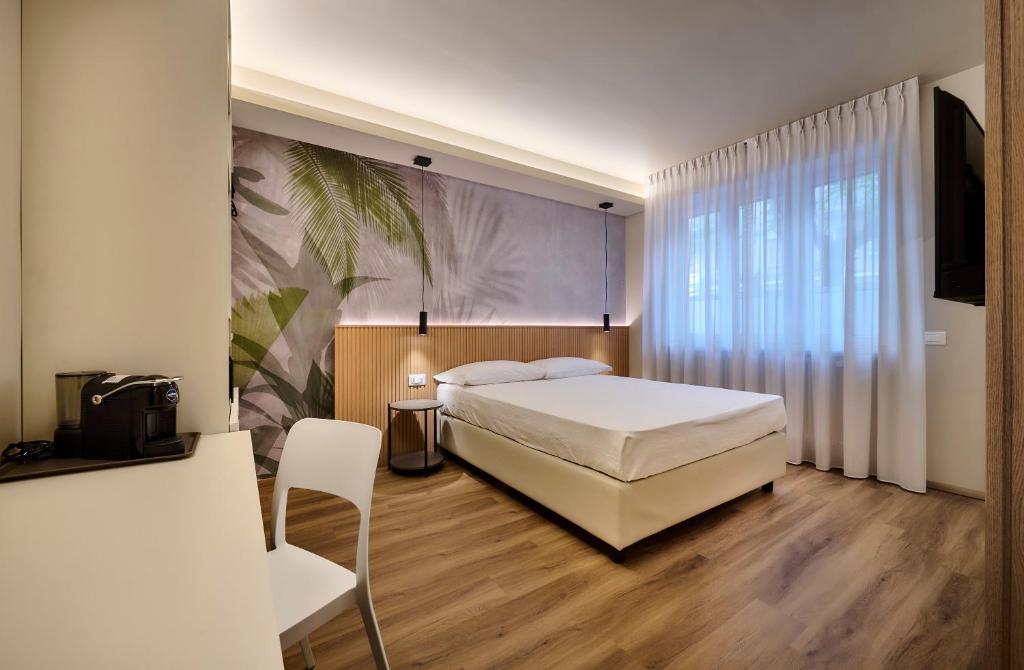 a bedroom with a bed and a chair in it at Monolocale 3 - viale Turati, Lecco in Milan