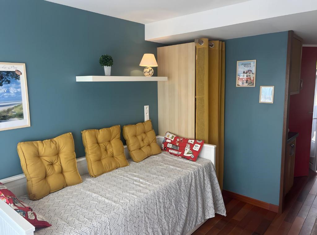 a bedroom with a bed with a yellow chair at Studio Face Mer in Quend-Plage