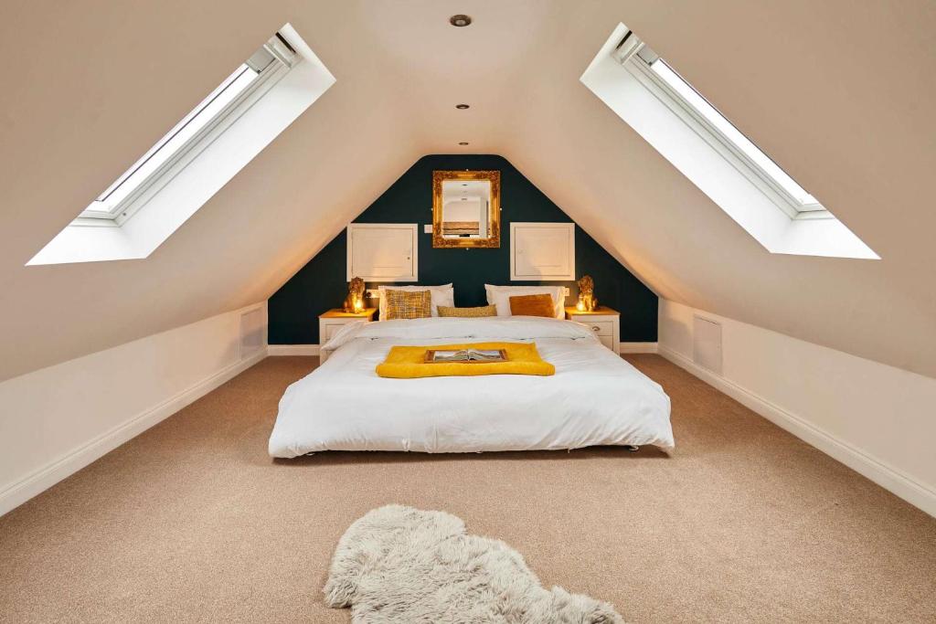 a attic bedroom with a bed and two skylights at Host & Stay - Beagle Barn in Withington