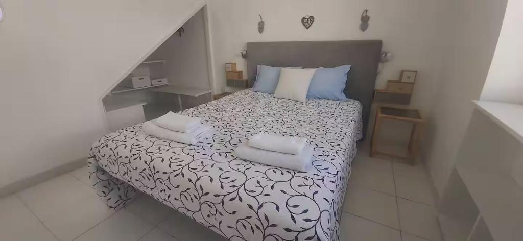 a small bedroom with a bed with pillows on it at Sweet West in Lourinhã