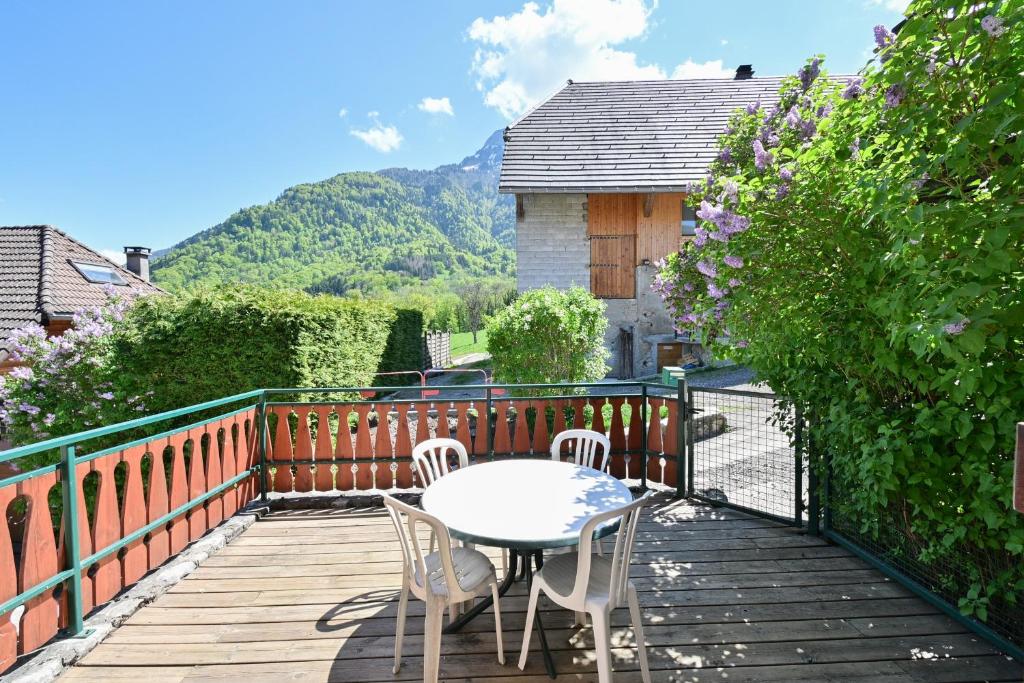 a wooden deck with a table and chairs on it at Appartement Le Rucher in Alex