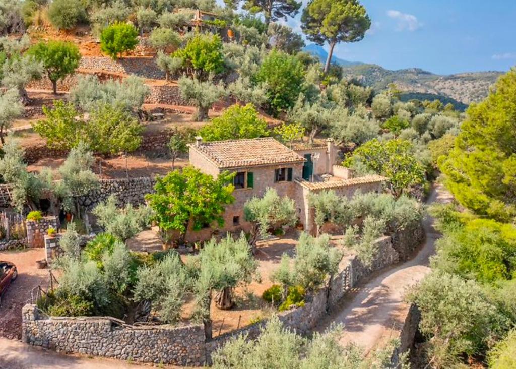an old house on a hill with trees and bushes at Es Coco Mountain Cottage in Sóller by PriorityVillas in Port de Soller