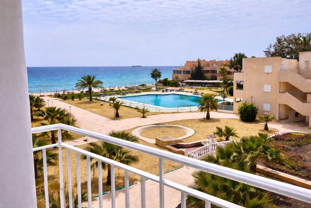 a balcony view of a swimming pool and the ocean at Vera Naked in Vera