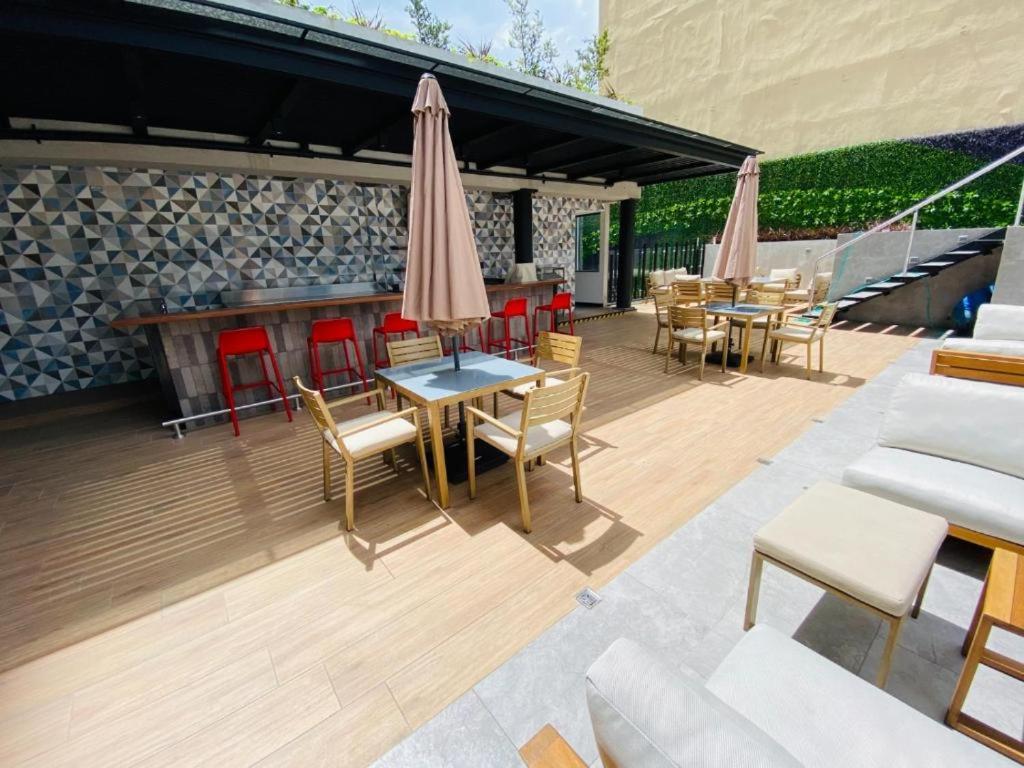 a patio with tables and chairs and umbrellas at EON Two Bedroom Apartment 1303 in Estación Pamplona