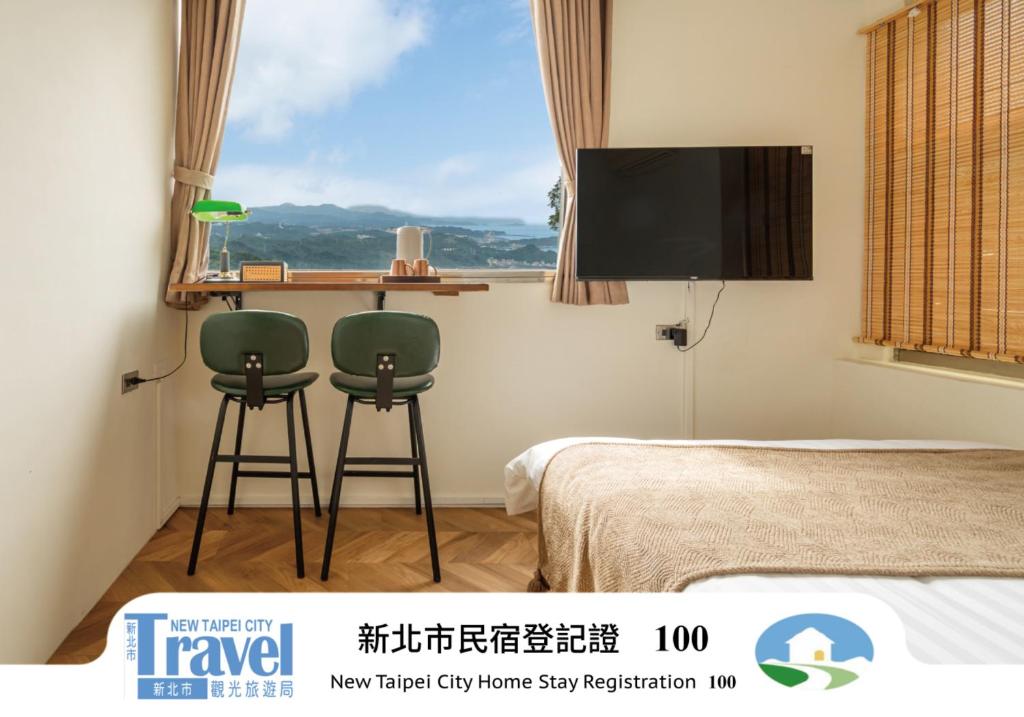 a bedroom with two green chairs and a tv at Pet Friendly Nostalgic Inn in Jiufen