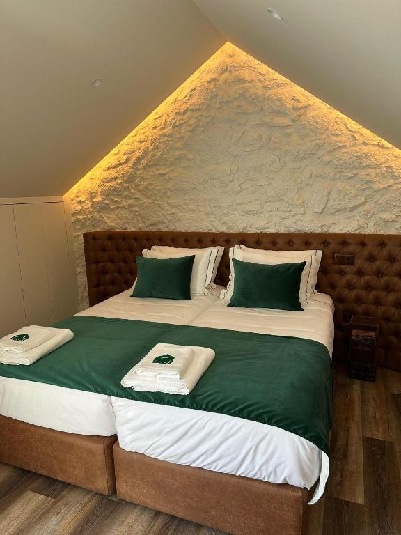 a bedroom with two beds with green and white sheets at Celtic Lodge - Guest House in Viseu