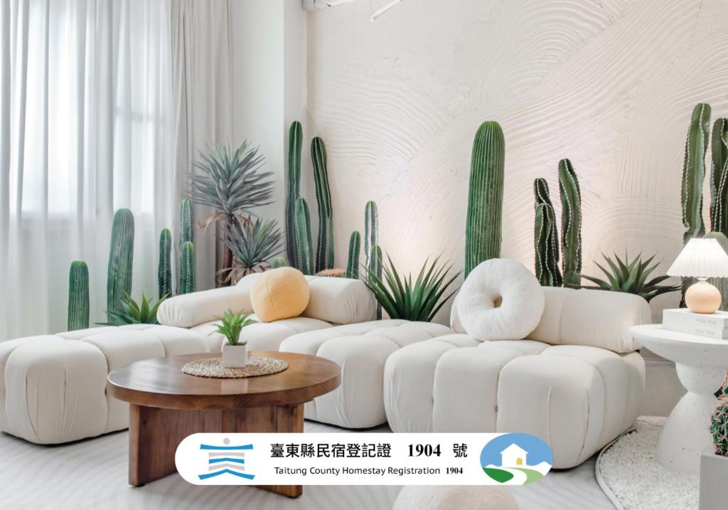 a living room with white furniture and cactuses at Pet Friendly Taitung Chun Yang Smart Stay in Taitung City