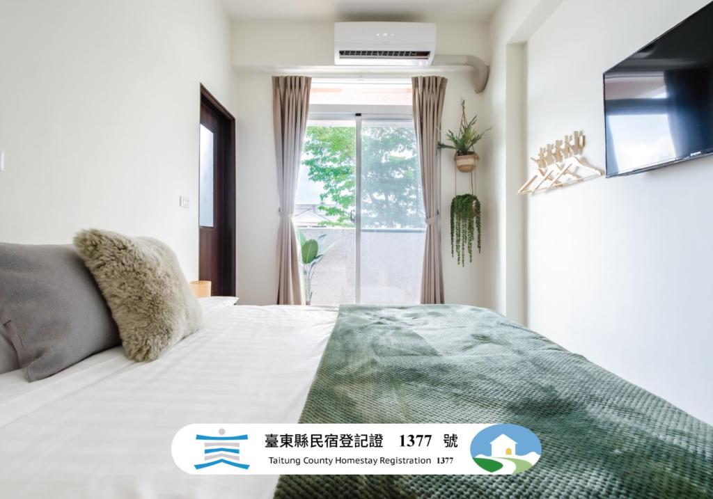a bedroom with a bed and a window at Pet Friendly Bear Station Smart Stay in Taitung City
