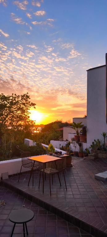 a table and chairs on a patio with the sunset at Guesthouse Acherusia in Bacoli