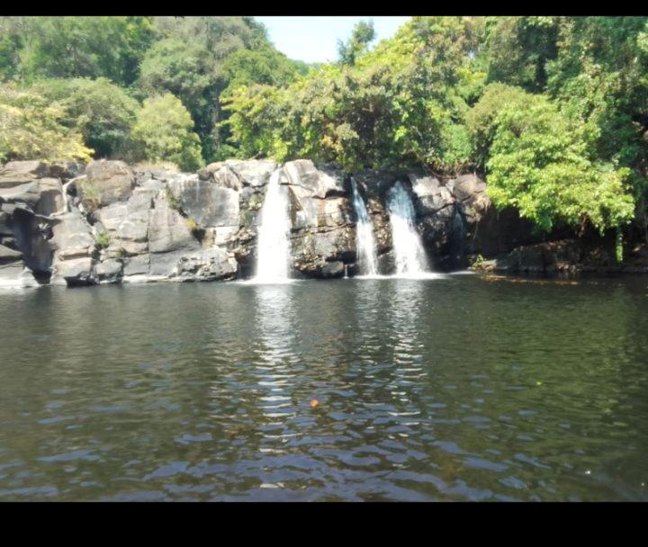 a waterfall in the middle of a body of water at COORG CLlMATE FARM HOUSE in Madikeri