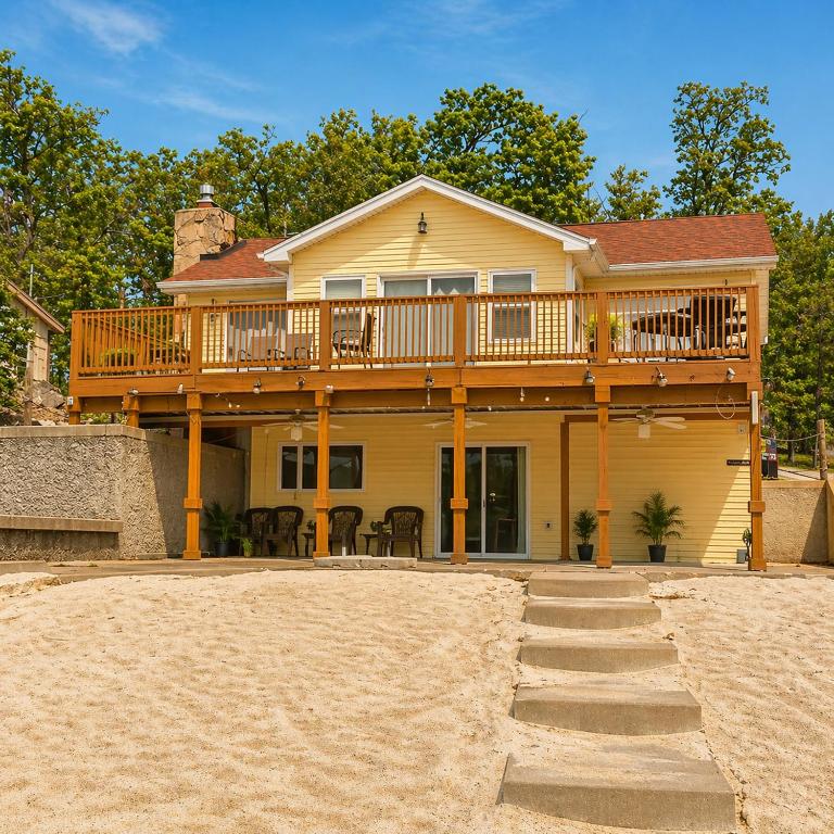 a house with a deck on the beach at Buccaneer Bay #28 - Beachfront Bliss in Sunrise Beach